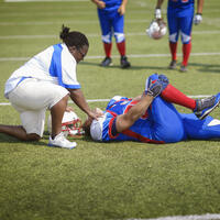 Football player with athletic trainer