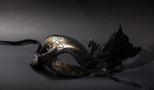 Carnival mask with feathers on black background