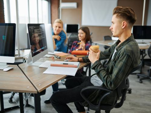 Young IT specialists works on computers in office