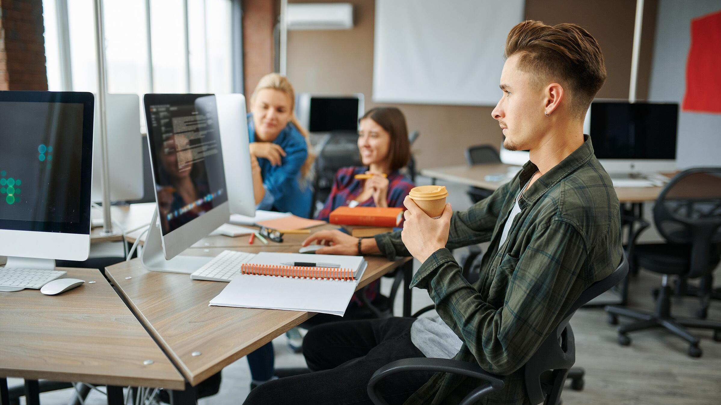 Young IT specialists works on computers in office