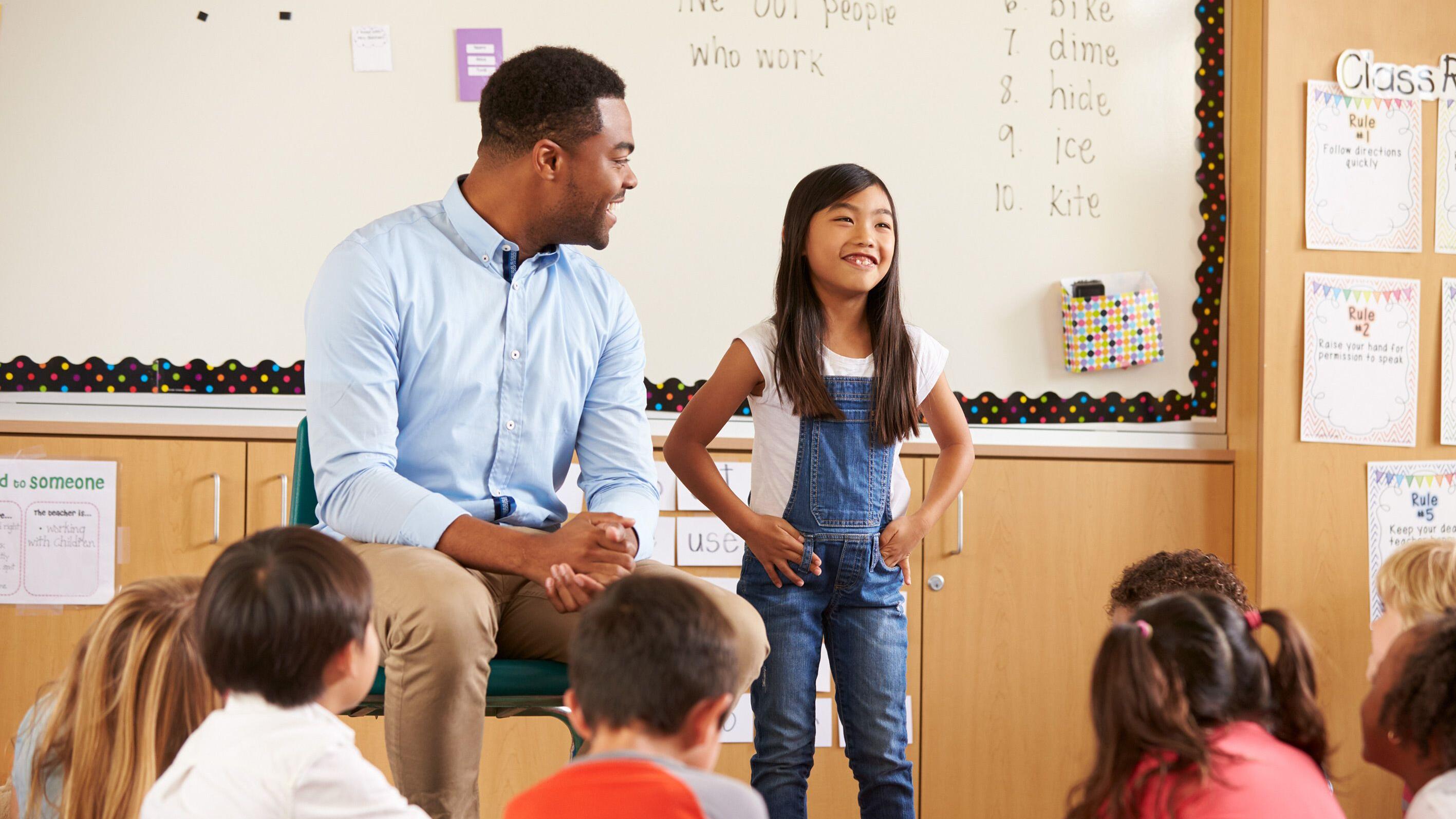 Schoolgirl at front of elementary class with teacher