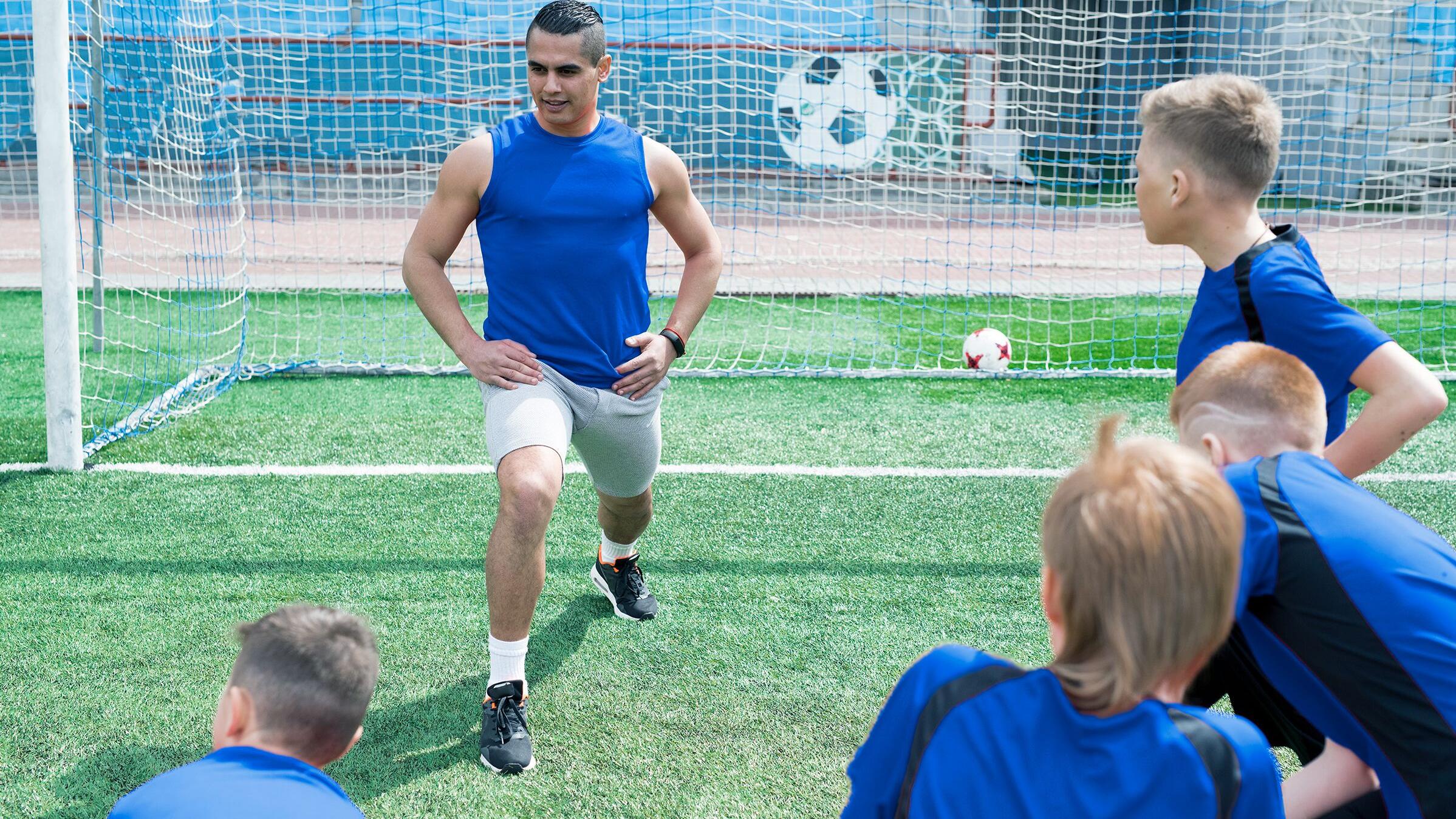 Soccer coach showing exercise - physical education - teacher