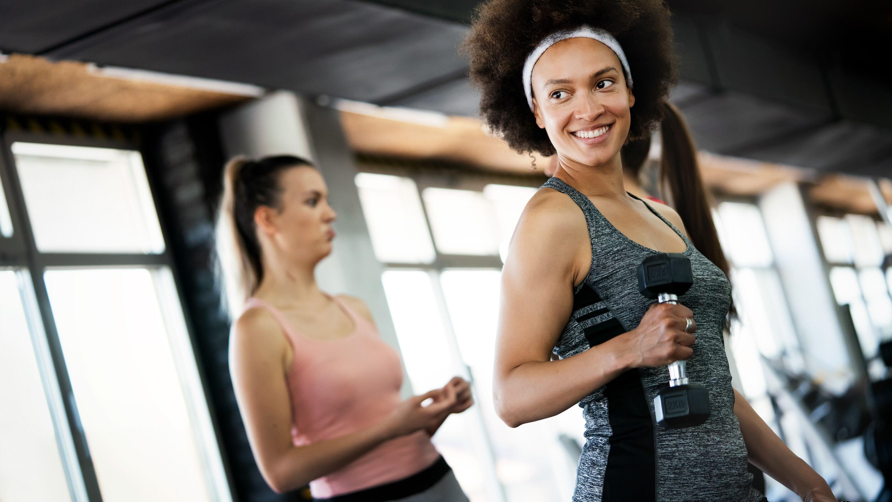 Beautiful fit people exercising together in gym