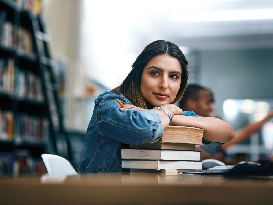 Student leaning on books